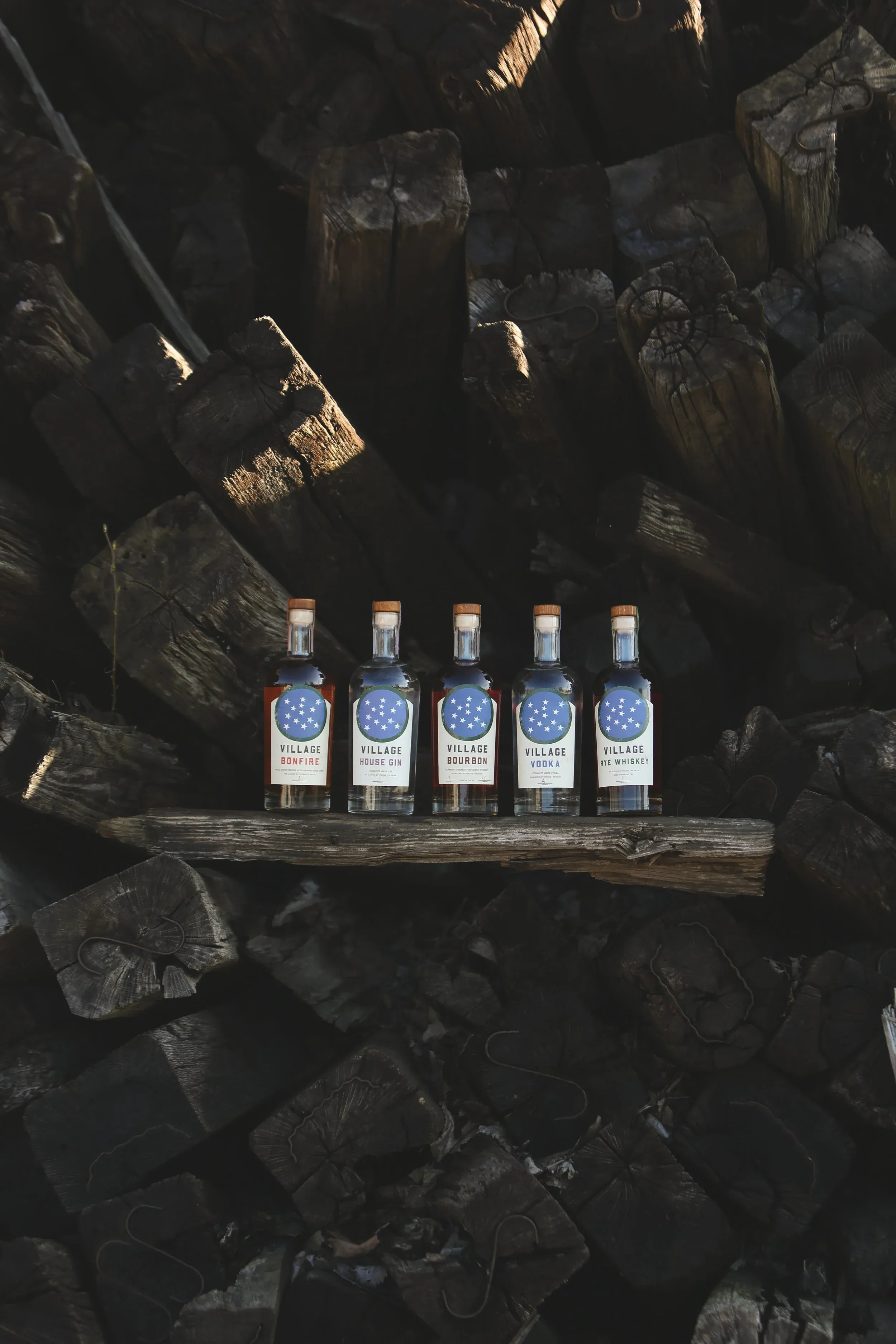 The Village Garage spirits line-up displayed on charred wood